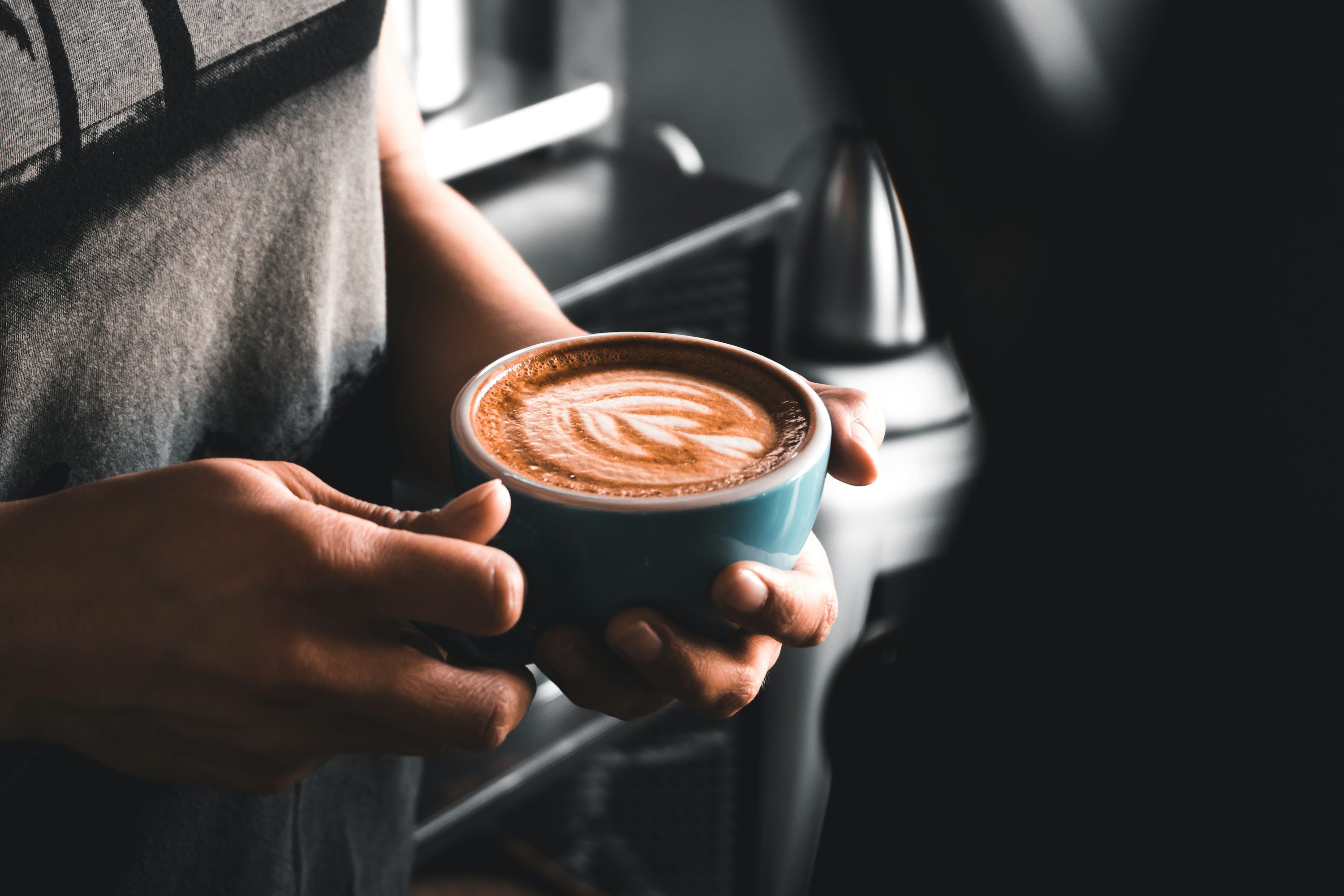 Close-up of hands holding a cup of freshly brewed coffee