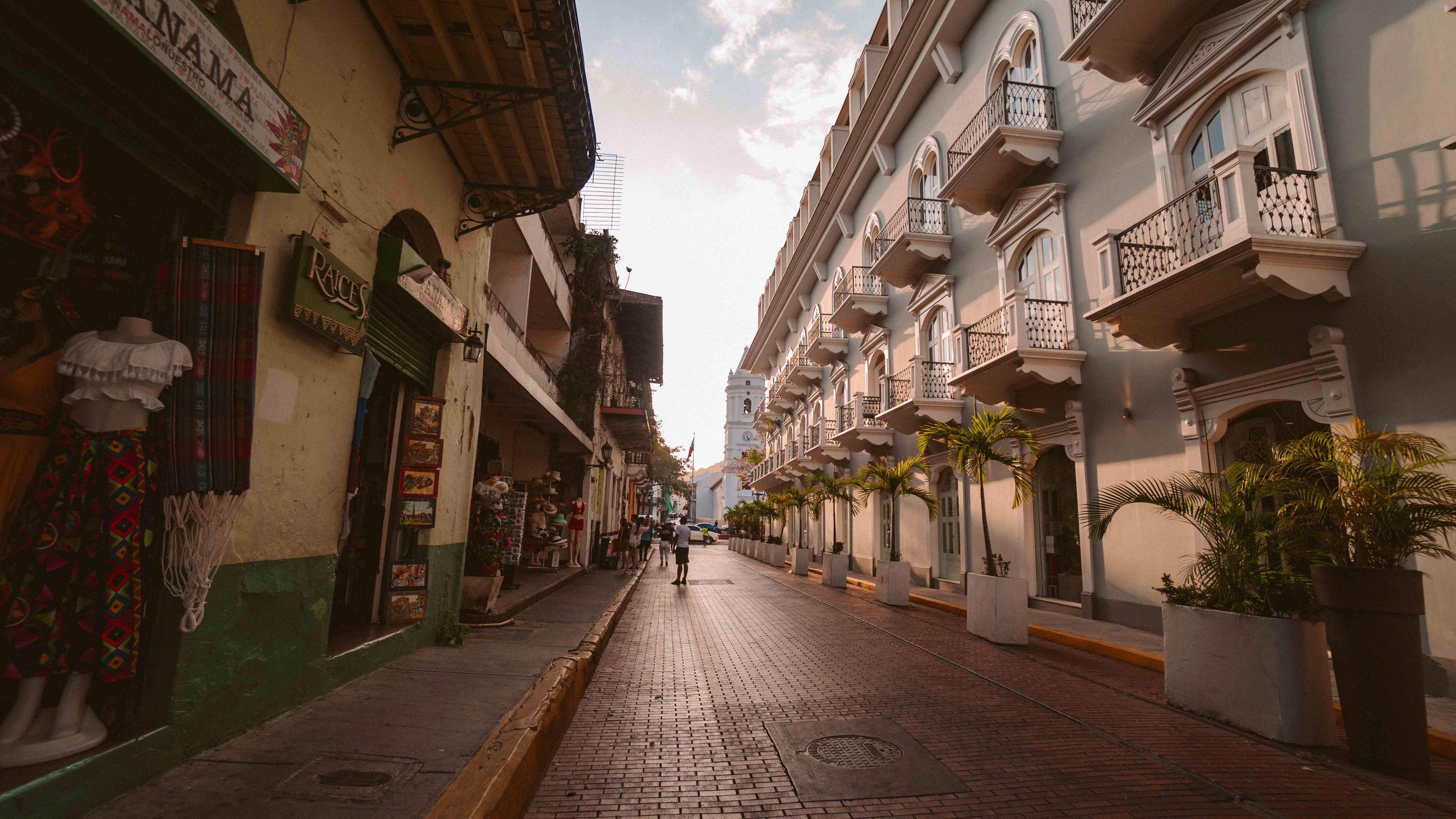 Traveler walking a cobblestone street past colonial buildings in Granada, Nicaragua
