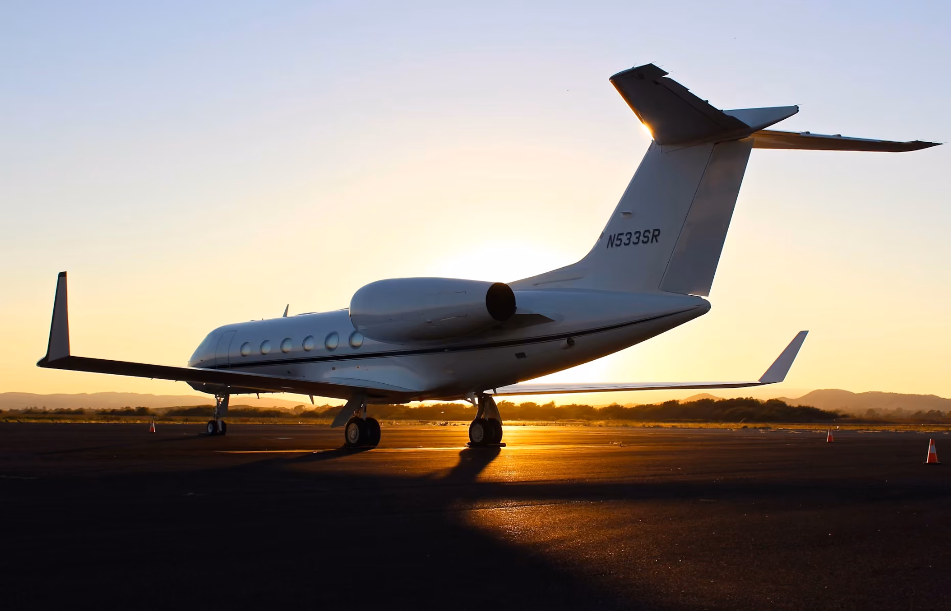 Private jet parked on sunlit airport tarmac