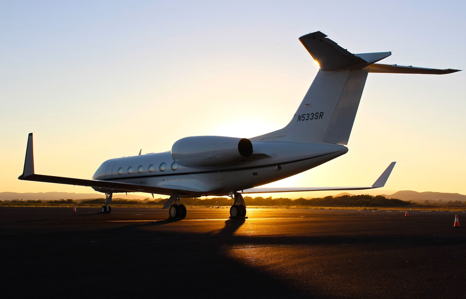 Private jet parked on sunlit airport tarmac