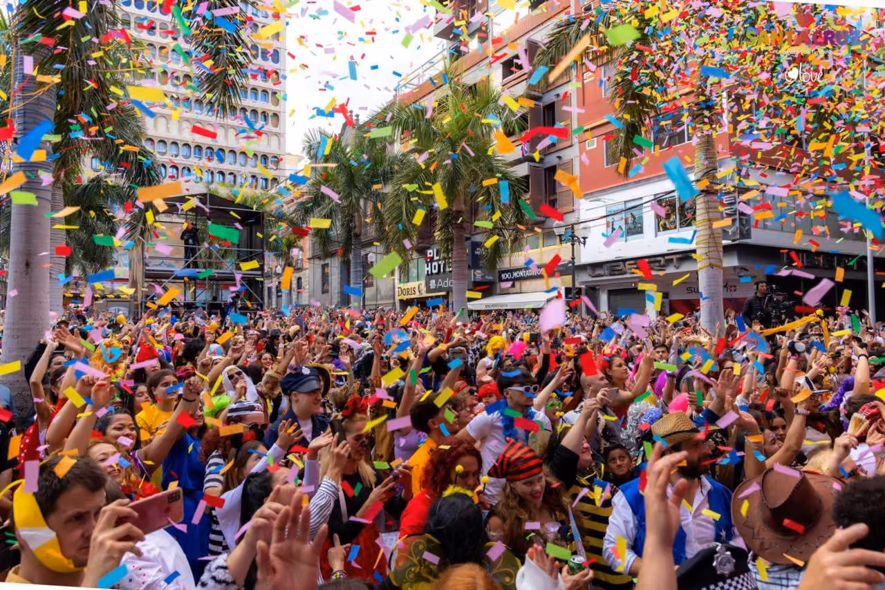 Costumed crowd celebrating with colorful confetti at Tenerife's Carnival, Santa Cruz.