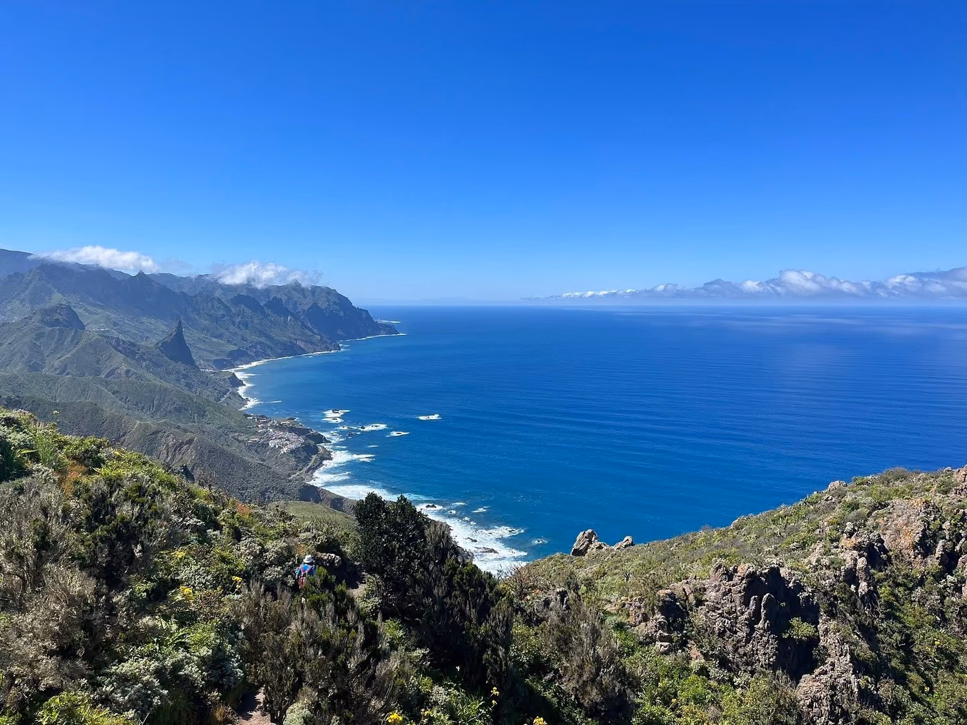 Panoramic coastal view of green cliffs meeting the Atlantic Ocean in Anaga Rural Park, Tenerife.