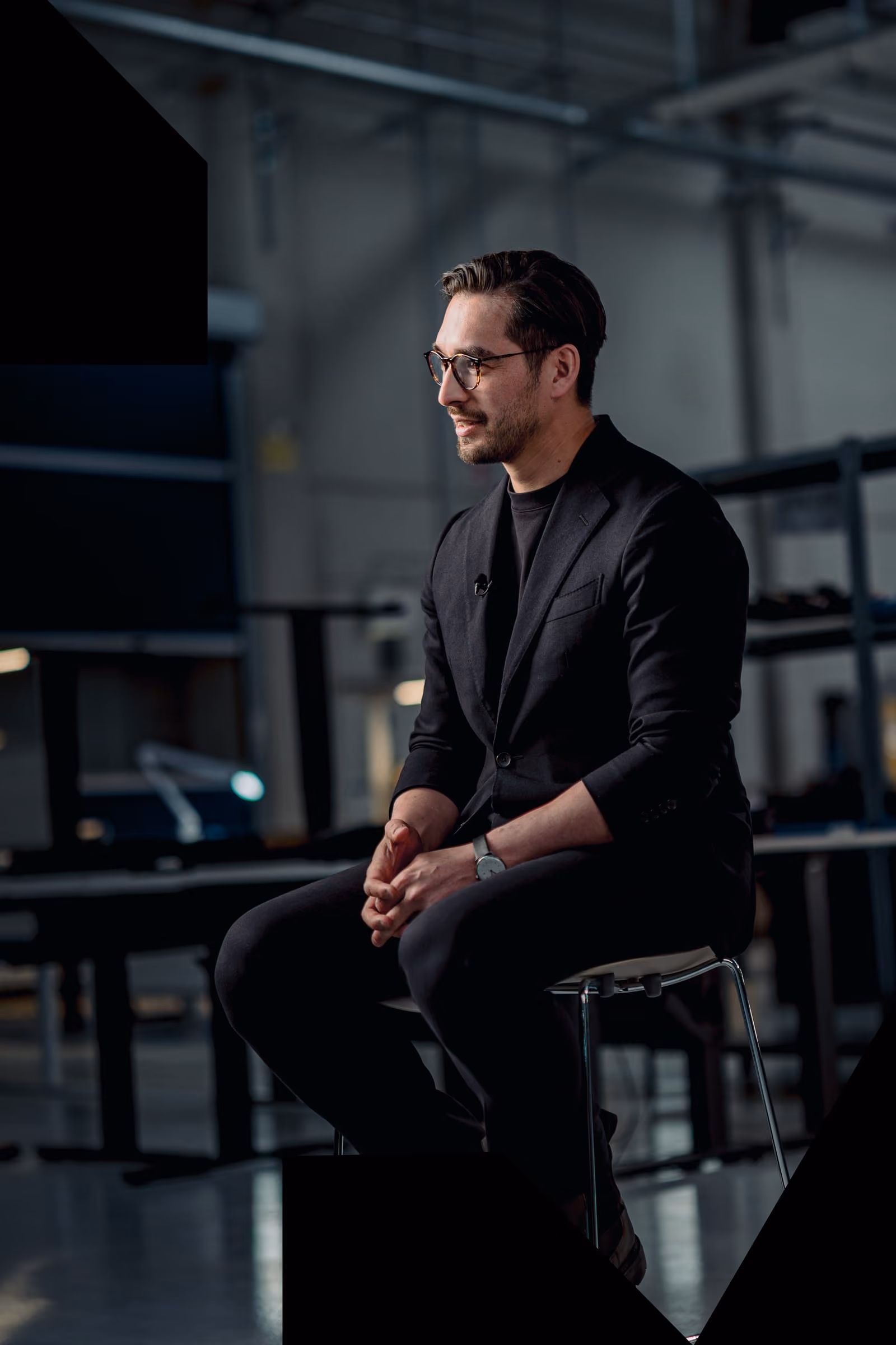 Quantum Frontline Industries founder Matthias Lehna sitting on a chair against an industrial background.