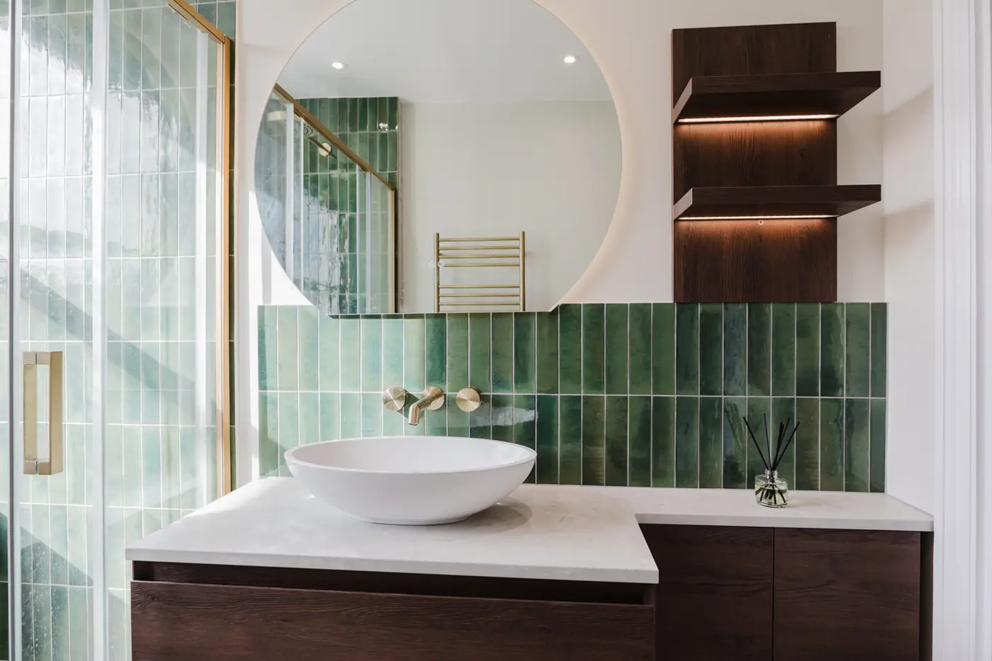 Completed washing area with wide vanity, storage, illuminated shelves and circular mirror