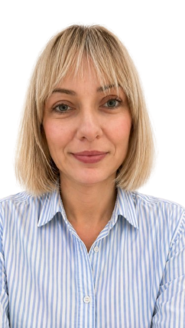 Blonde woman with shoulder-length hair wearing a blue and white striped button-up shirt.