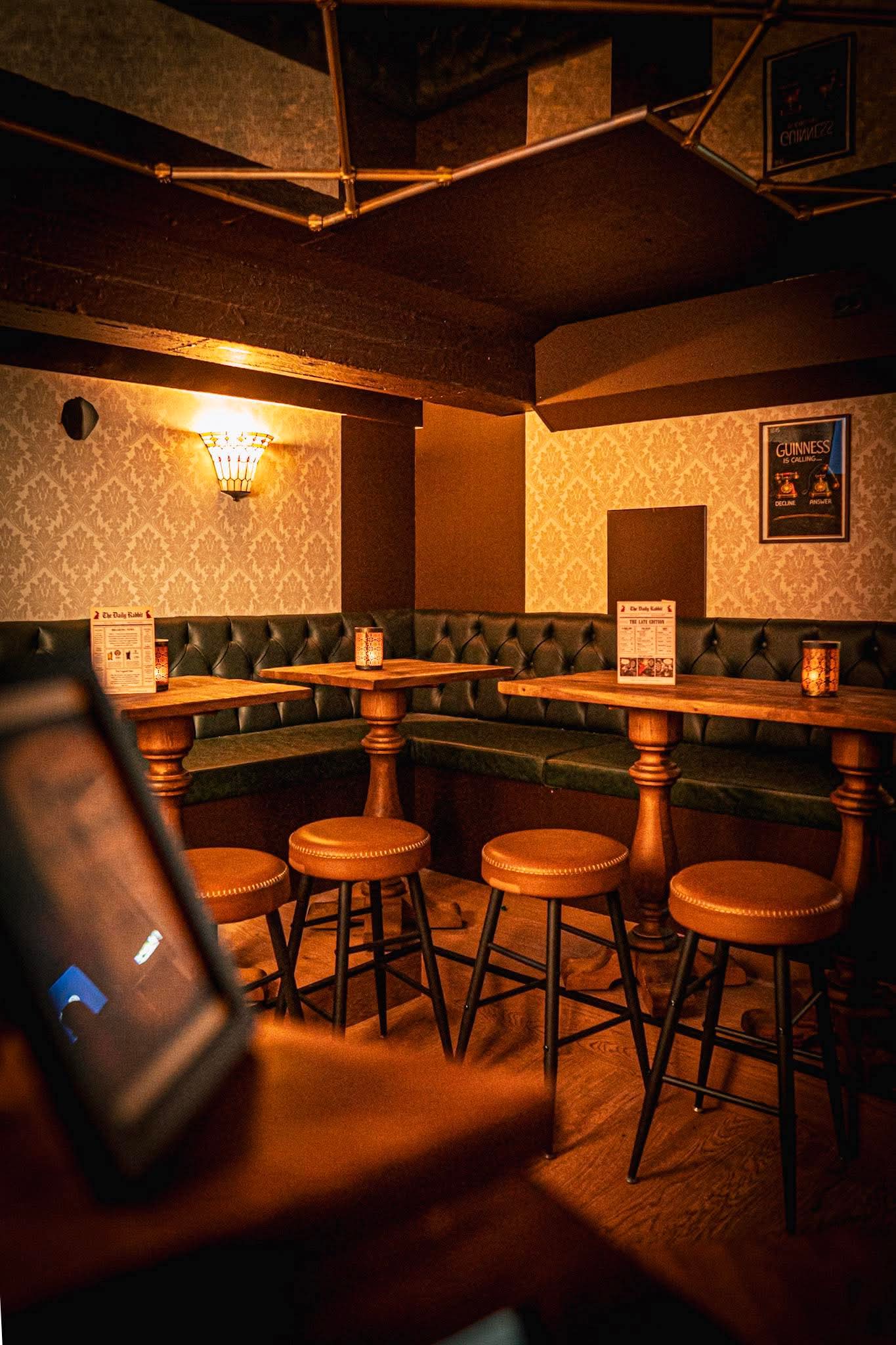 Private basement room at Red Rabbit Pub Oslo with green leather booth seating and bar stools, available for group bookings and events