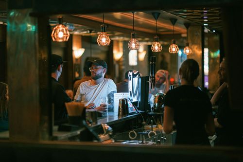 Private basement room at Red Rabbit Pub Oslo with green leather booth seating and bar stools, available for group bookings and events