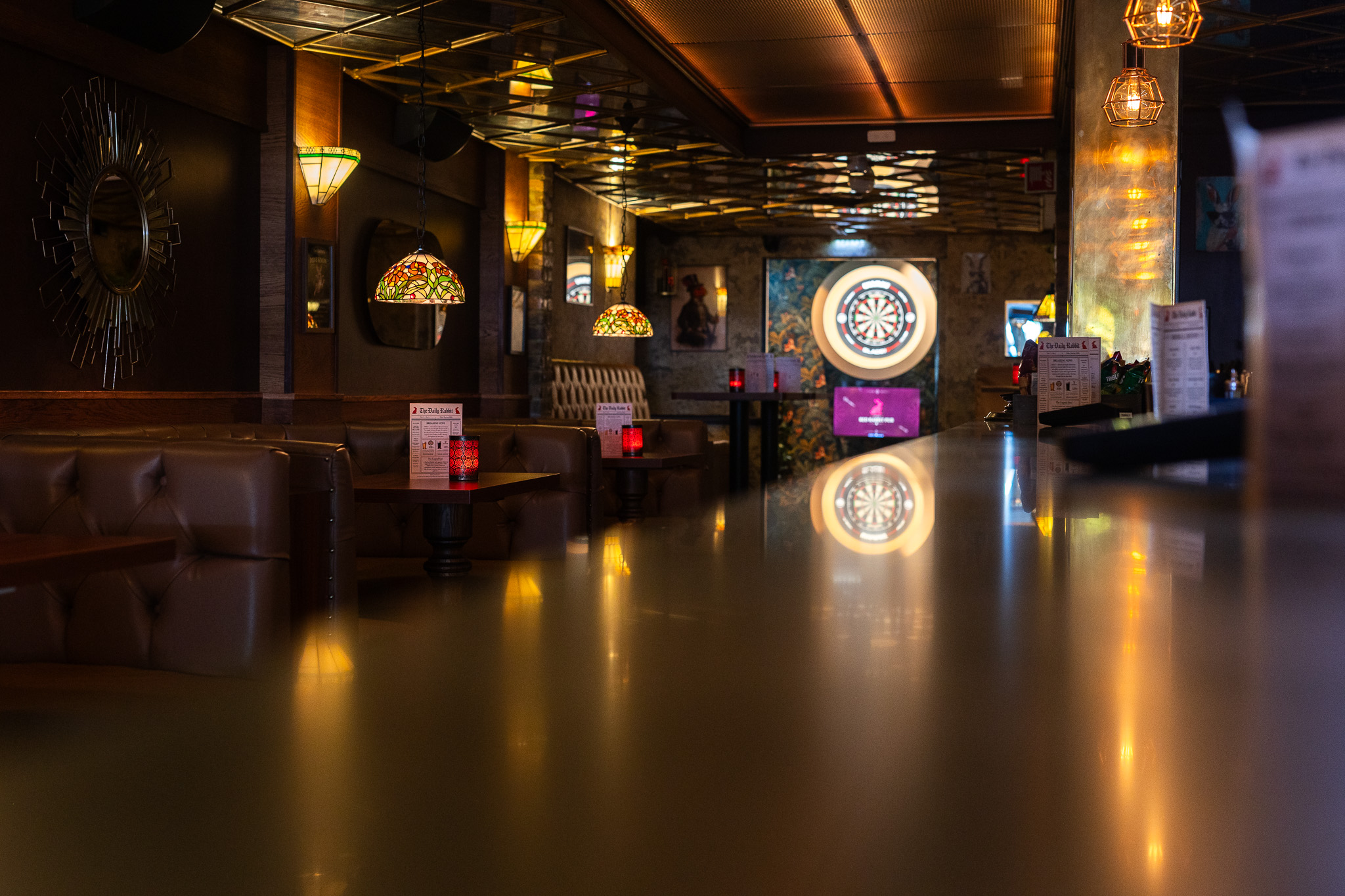 The interior of Red Rabbit Pub Oslo with an illuminated dartboard