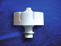 White plastic breather valve component on a blue fabric background.