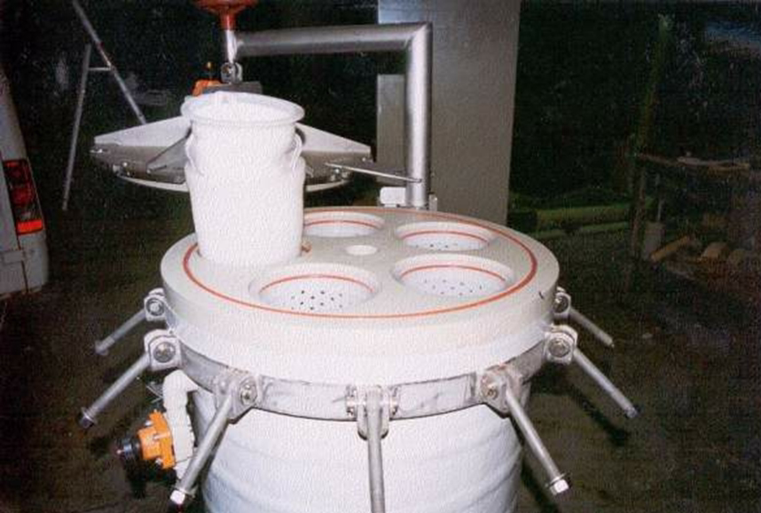 Industrial stainless steel machine with circular components and metal handles in a workshop.
