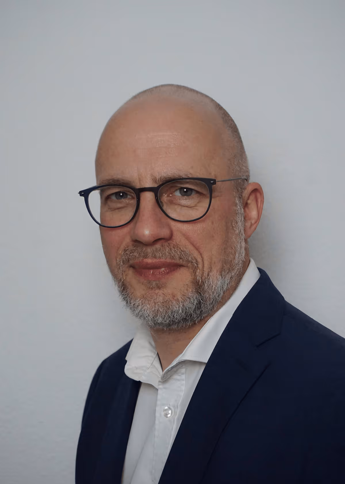 Moderner Büro-Arbeitsplatz mit Laptop, Kaffeetasse und Pflanzen auf einem Schreibtisch, beleuchtet durch natürliches Tageslicht.