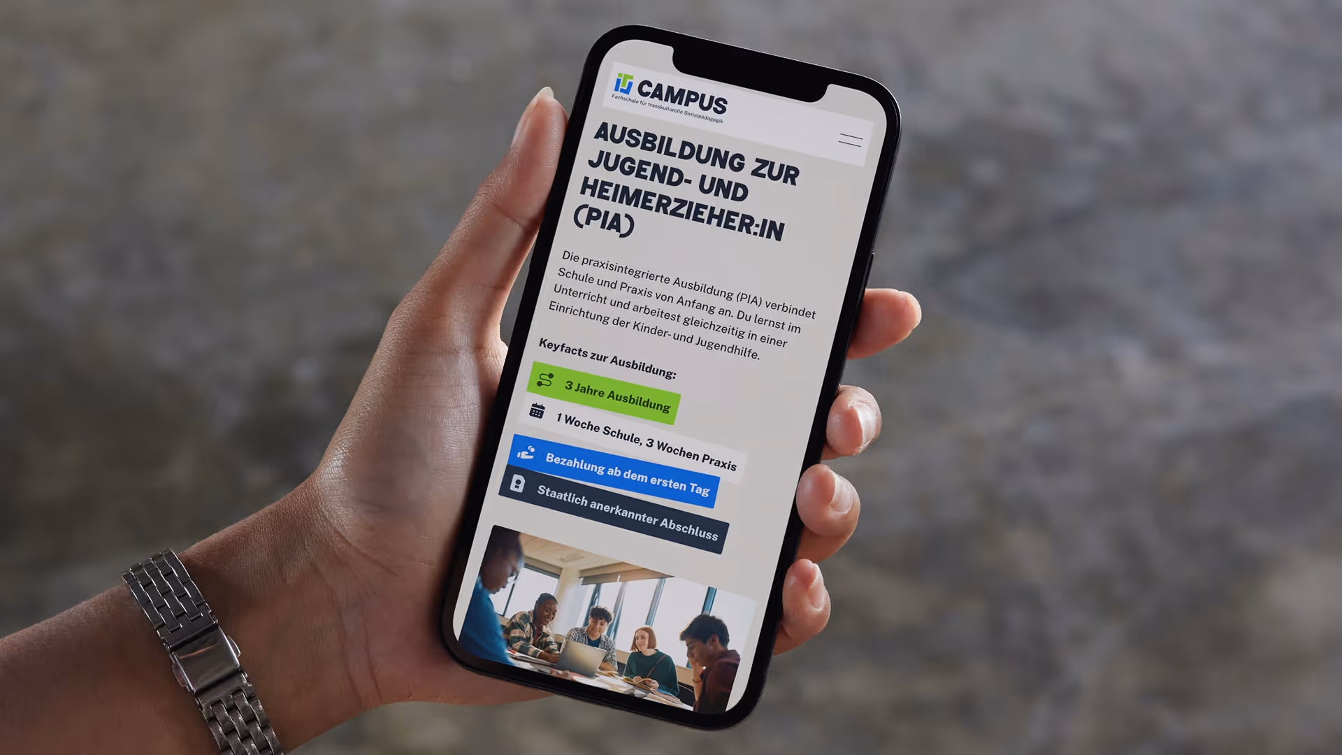 Hand hält Smartphone mit Website zur Ausbildung zum Jugend- und Heimerzieher mit Schlüsselinfos und Bild von Gruppe an einem Tisch.