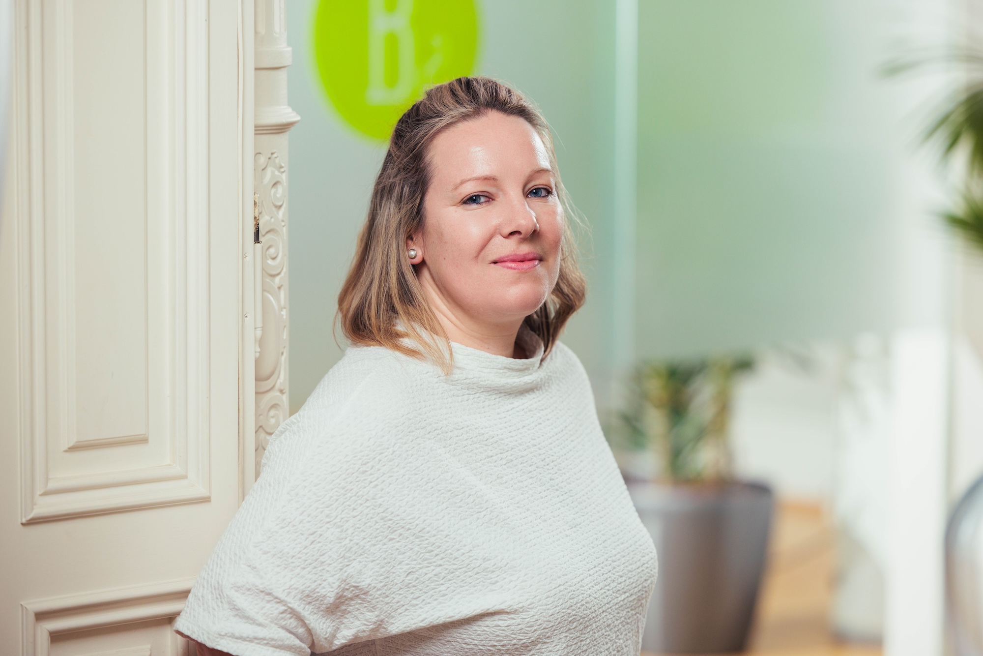 Porträt einer blonden Frau mit weißem Shirt.