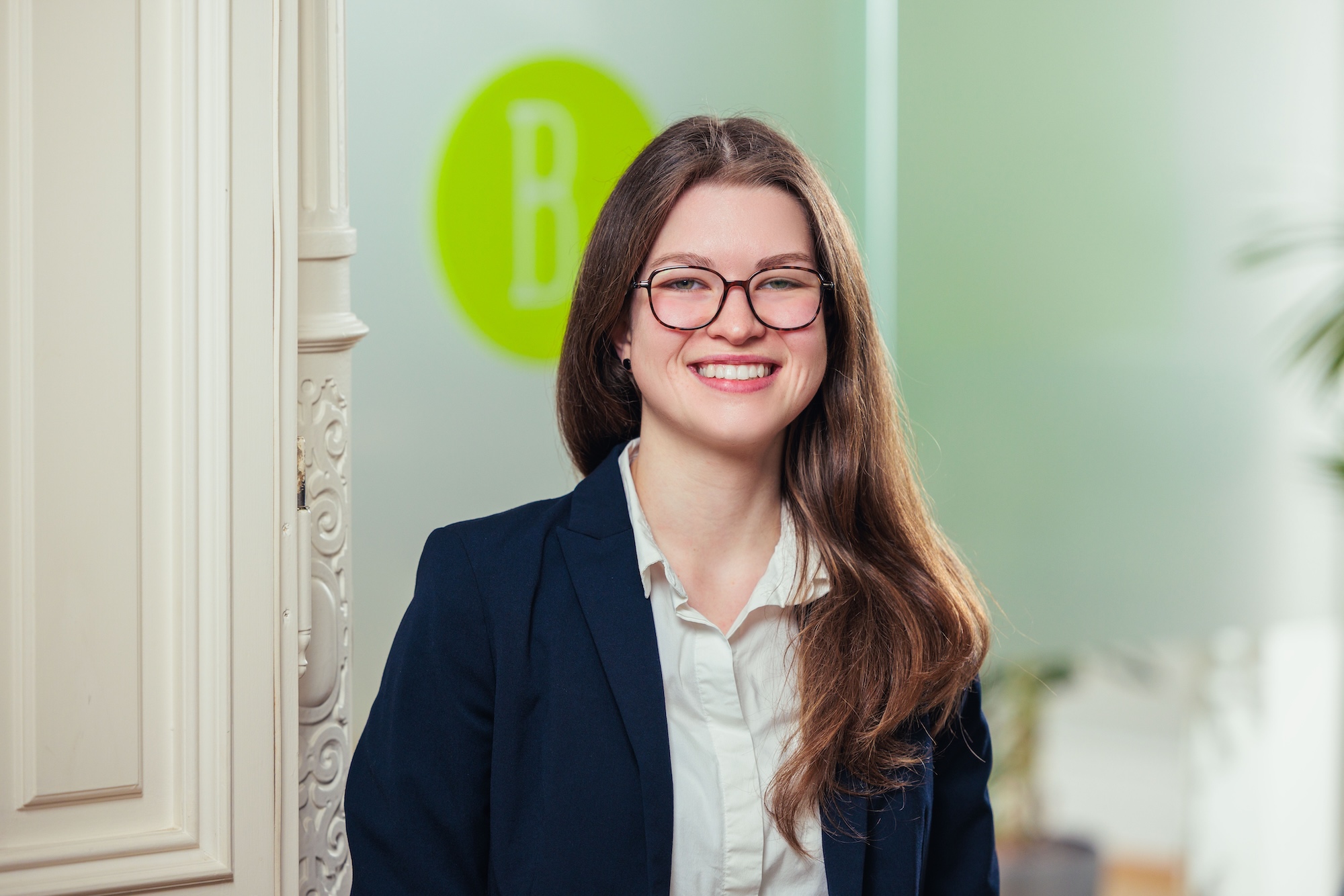 Porträt einer Frau mit langen hellbraunen Haaren und Brille.