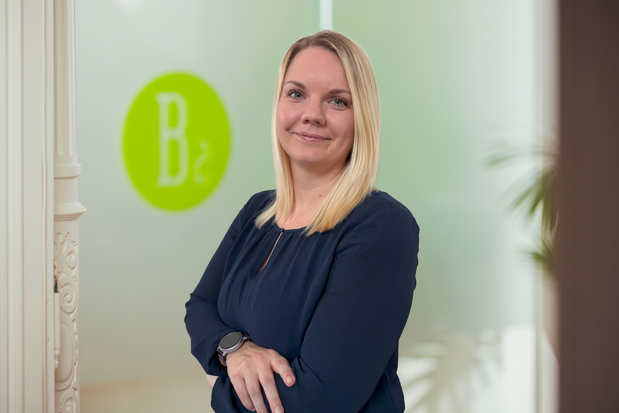 Porträtfoto einer blonden Frau mit dunkelblauer Bluse.