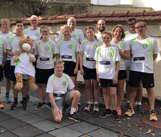 Gruppenfoto von Mitarbeitern der Kanzlei und Angehörigen, die alle ein gleiches Laufshirt tragen.