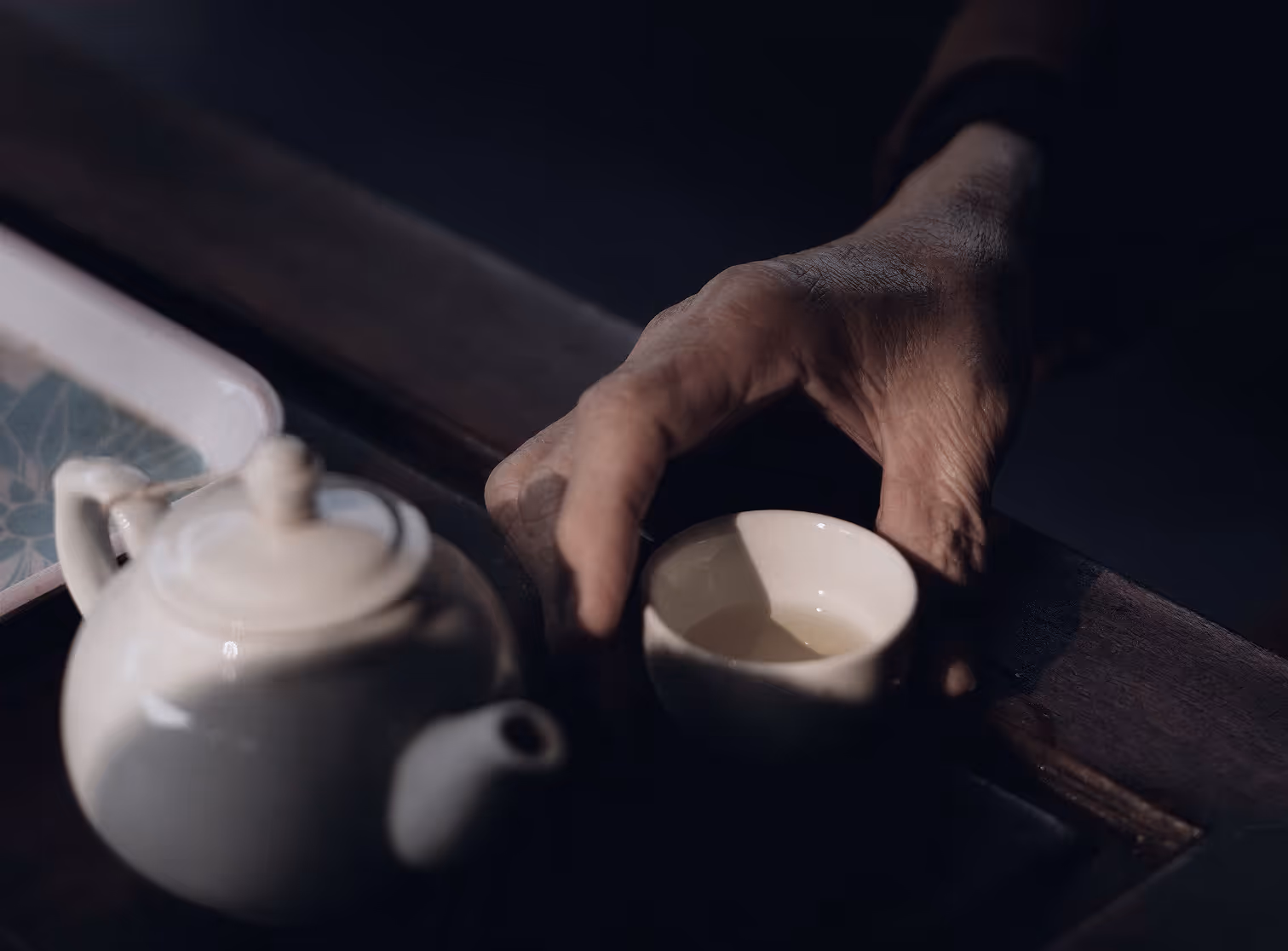 An old man holding a tea cup.