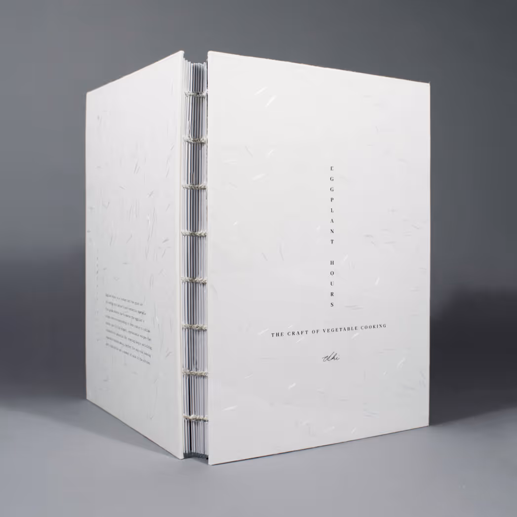 White Japanese paper cookbook cover with coptic stitch binding and black vertical typography