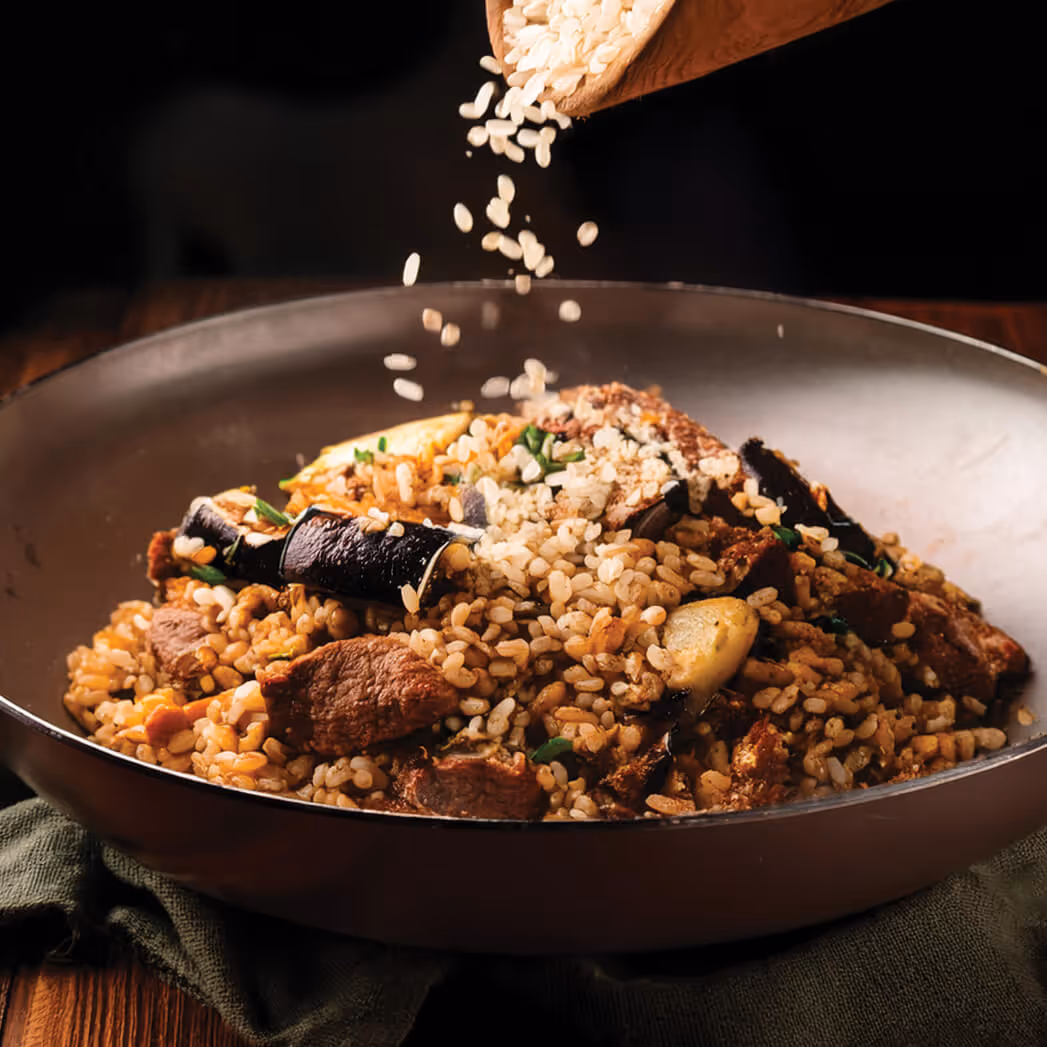 Eggplant halves on brown rice with cooked vegetables and sesame seeds