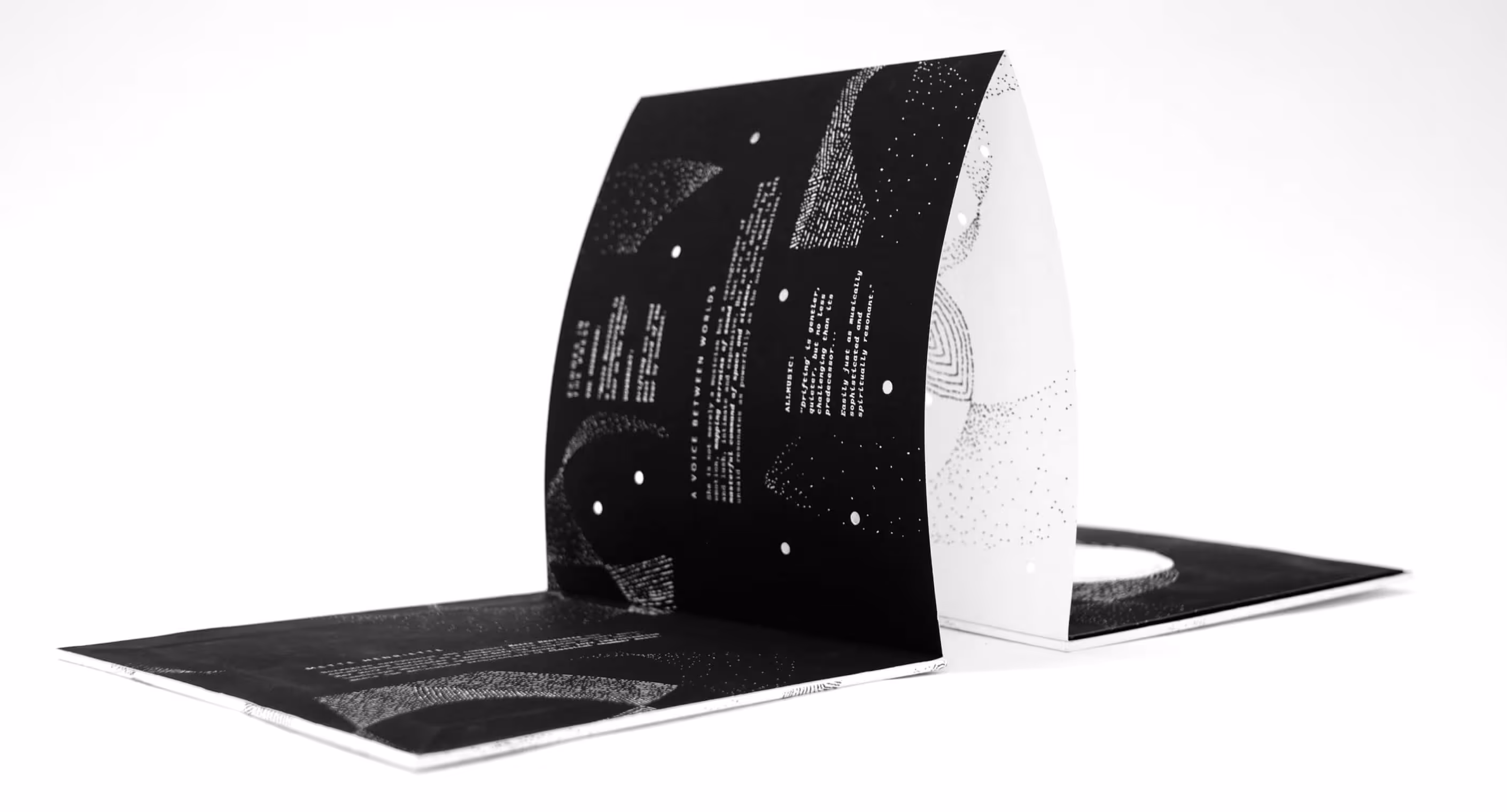 Vinyl packaging for Mette Henriette featuring black and white accordion fold thirty inches long with die cut circles and pointillism scattered across both sides
