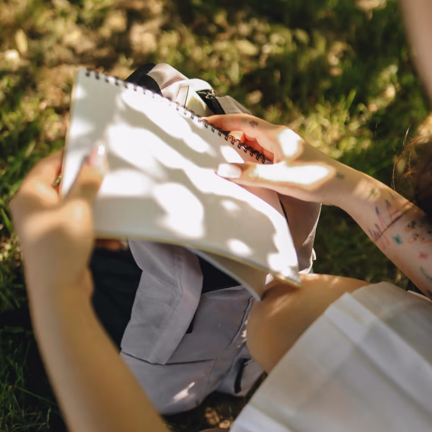 Woman sitting outside on bench holding Ajenda notebook
