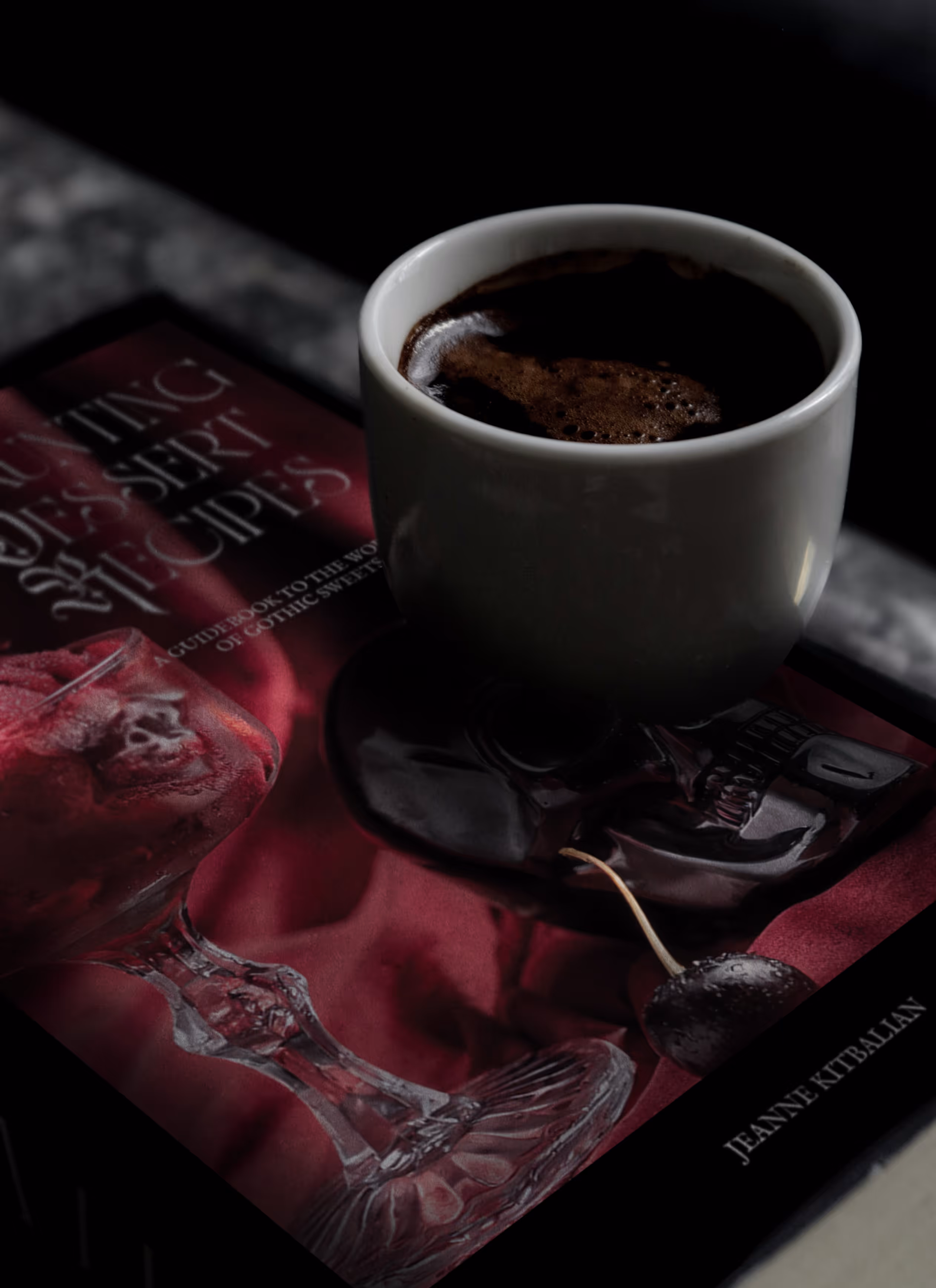 A cup of coffee standing on the cookbook