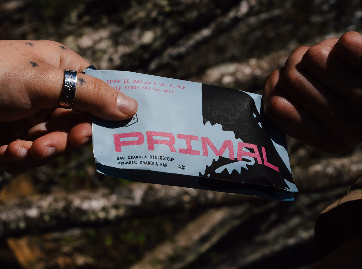 photo credit Felix Burke. Close up picture of a primal granola bar in between two hands.