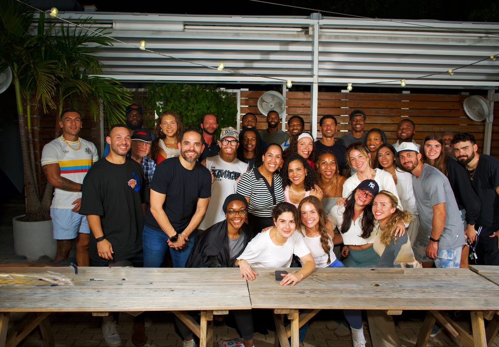 A Co-Ed Crew gathered around a long table outdoors