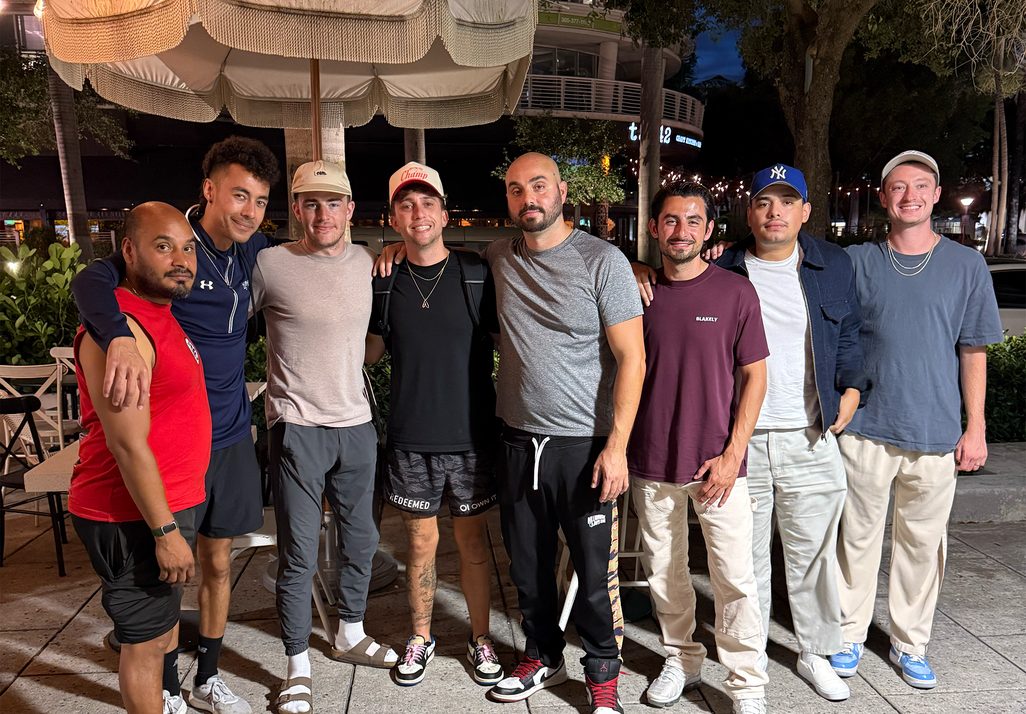 A Men's Crew standing together outside at night