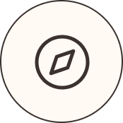 Simple black compass rose icon inside a black circle on a cream background.
