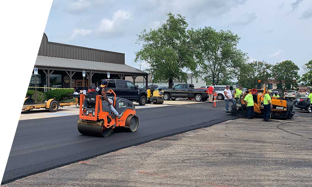 Heavy equipment laying fresh asphalt during a paving project with smooth surface finish
