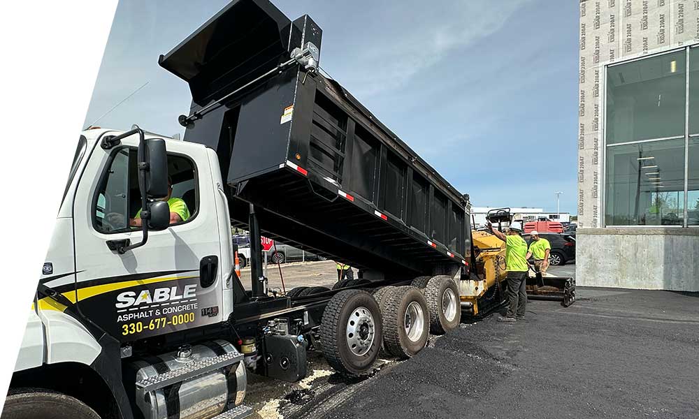 Heavy equipment laying fresh asphalt during a paving project with smooth surface finish
