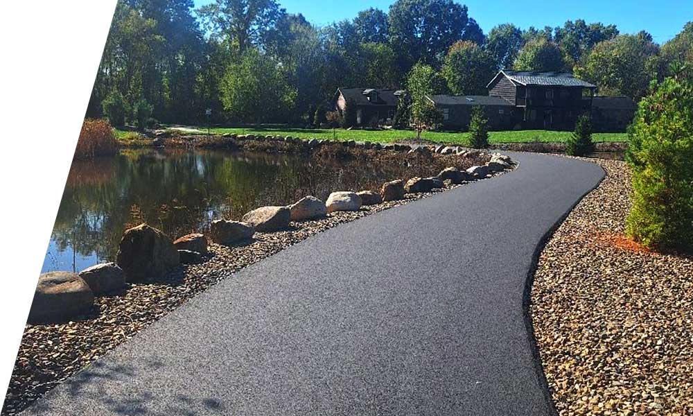 Heavy equipment laying fresh asphalt during a paving project with smooth surface finish
