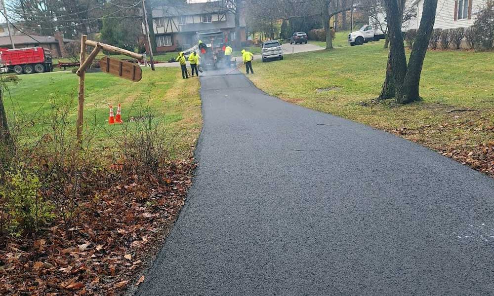 Residential asphalt driveway project with durable blacktop surface and clean grading