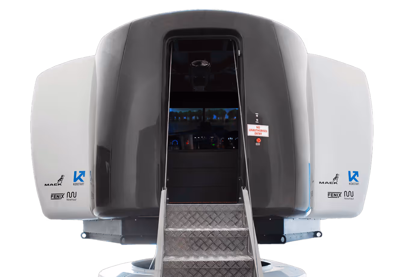 Front view of a modern vehicle simulator cockpit with steps leading up to an open entrance displaying a control panel inside.