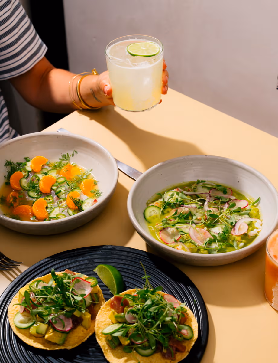 Fresh Mexican cuisine spread featuring colorful ceviche bowls, fish tacos with microgreens, and a margarita with lime