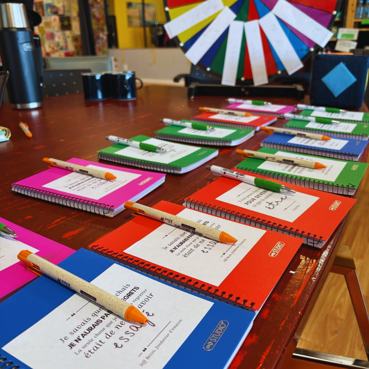 Calepins et stylos arrangés en rangées sur une table