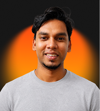 Smiling man with dark hair and a short beard wearing a gray shirt against a black and orange background.