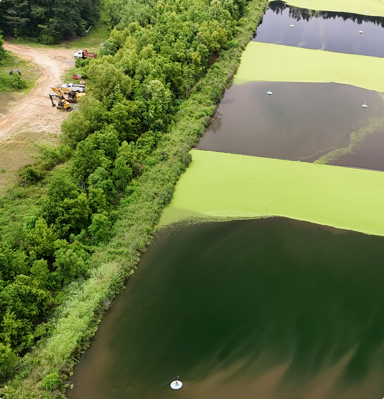 Aerial view of wastewater treatment ponds and construction equipment in Lowndes County, Alabama
