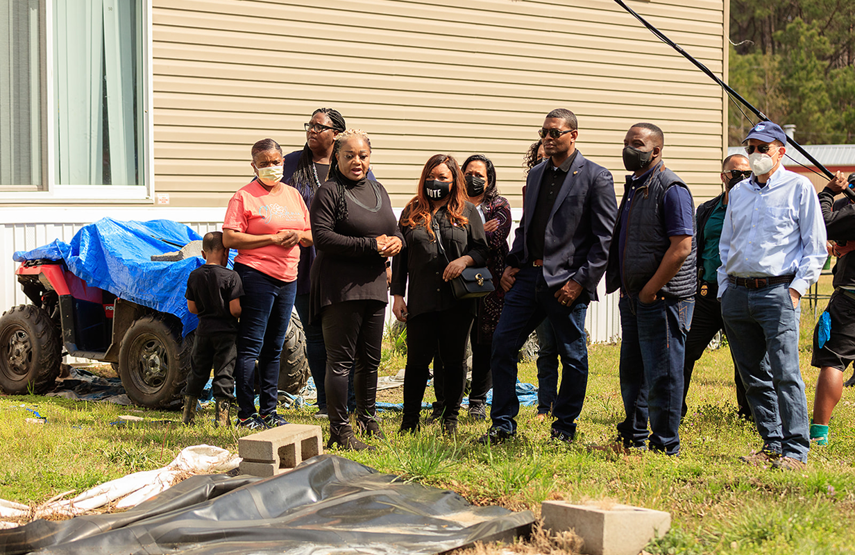 Catherine Coleman Flowers and agroup of volunteers in a back yard.