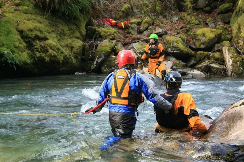 Smiling course participant wearing a helmet with a camera during outdoor rescue training