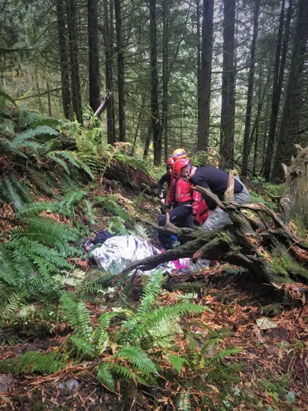 Instructor helping a climber check her harness and rope during rope rescue training