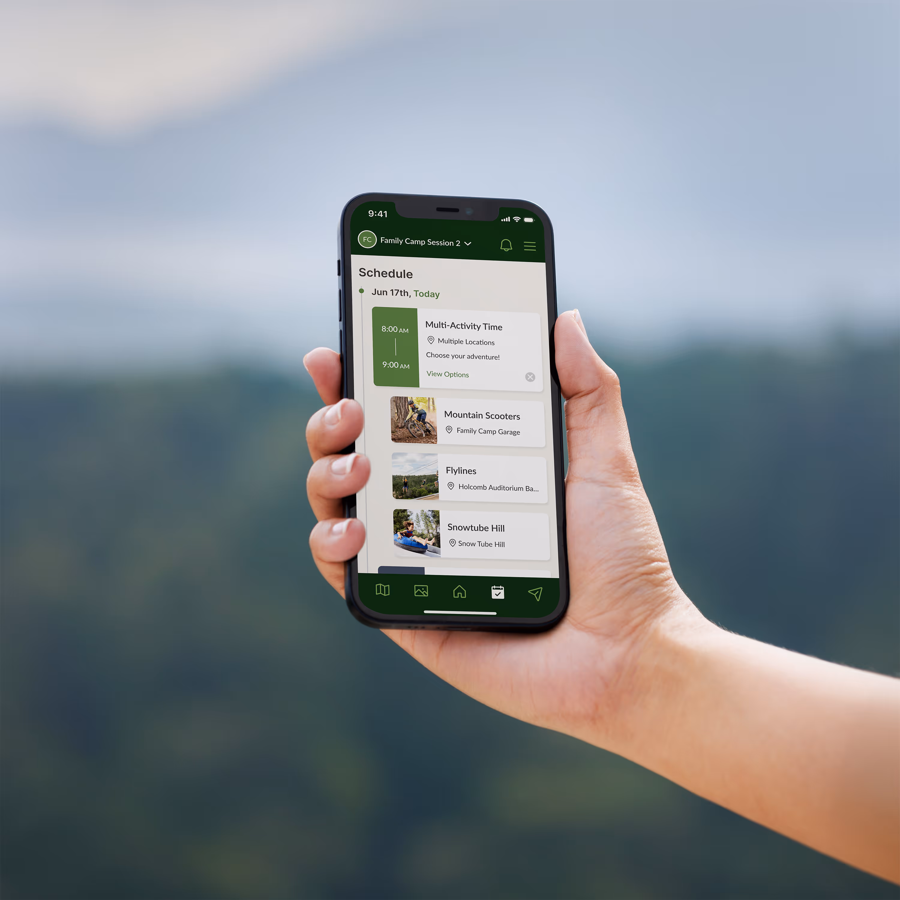 A person's arm holding a smart phone with the schedule screen from Glorieta's mobile app on it, with a forest in the background.