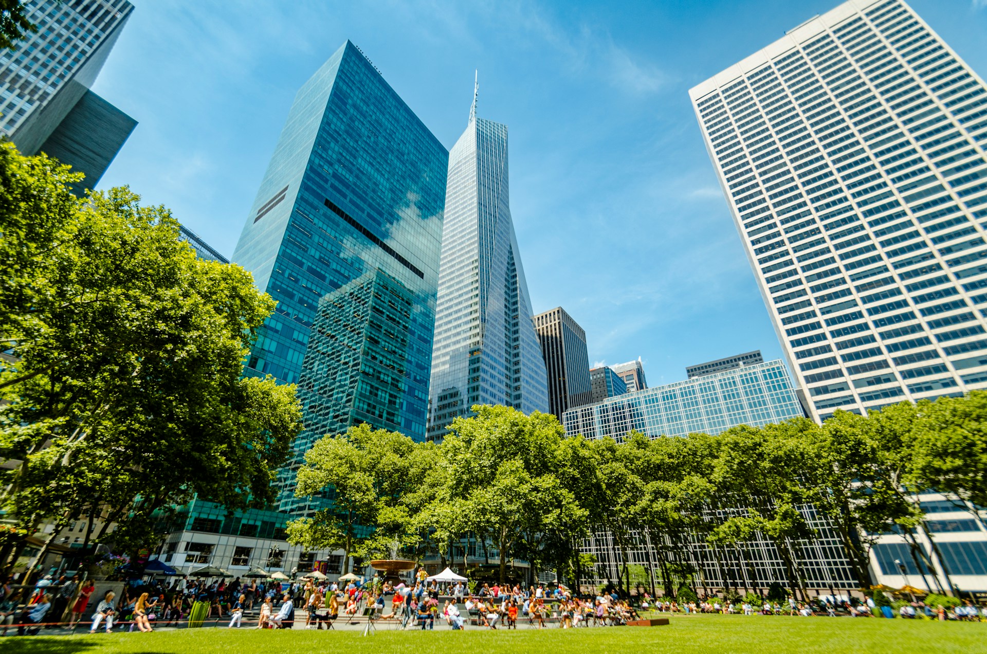 New York City towers rising above the trees and lawn of Bryant Park