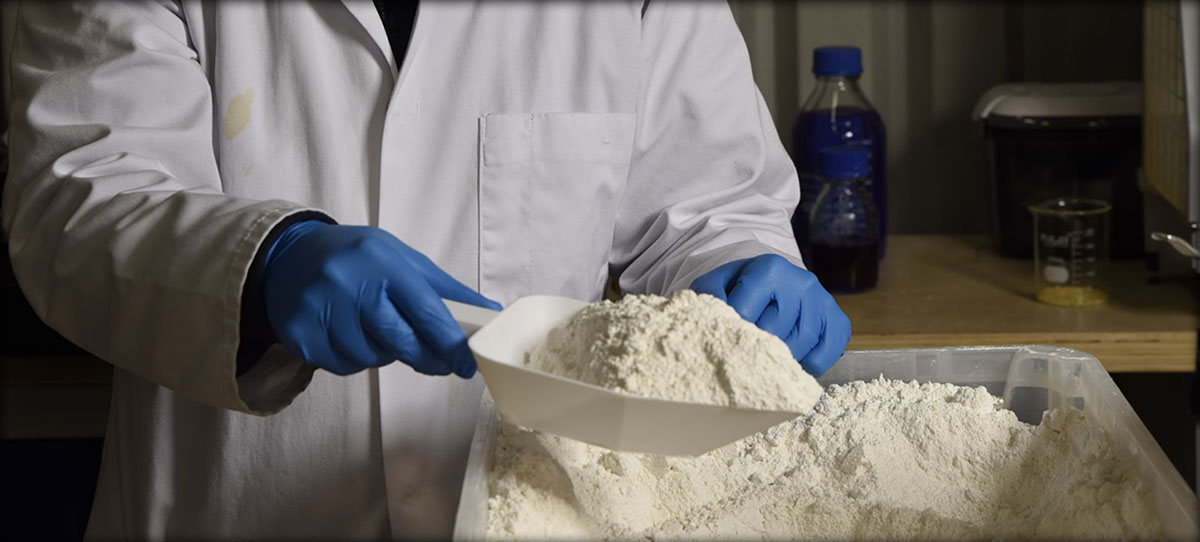 A Dekiln scientist measuring bio-based binder powder in a laboratory. 