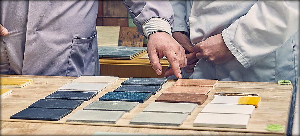 Dekiln team members discussing a range of coloured Eralith tiles. 