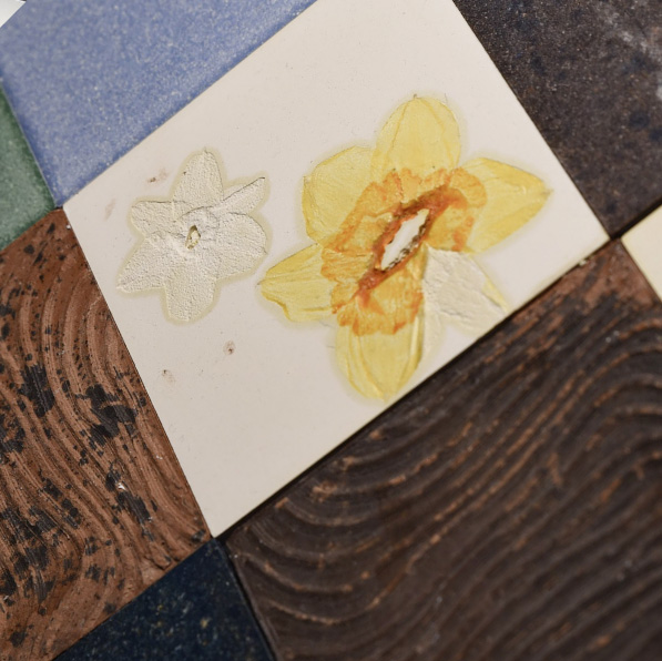 A decorative Eralith tile depicting a yellow flower. 