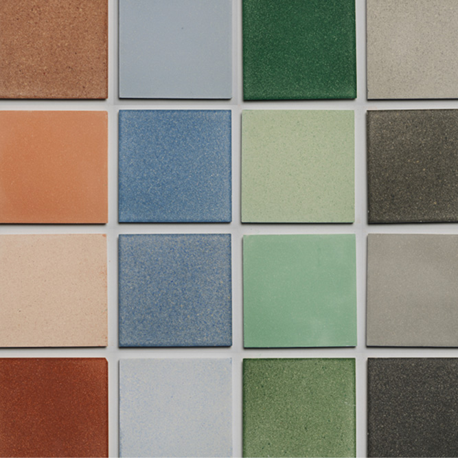 A composition of Eralith sustainable tiles in colour from green and blue to orange and grey. 