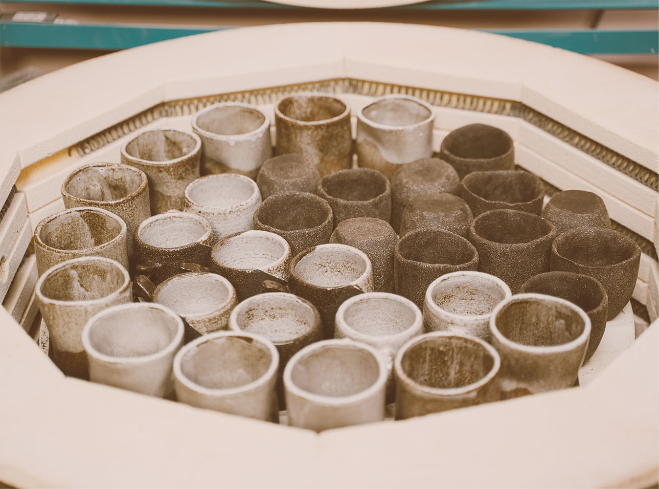 A traditional kiln containing ceramic pots, reliant on energy-intensive processes.