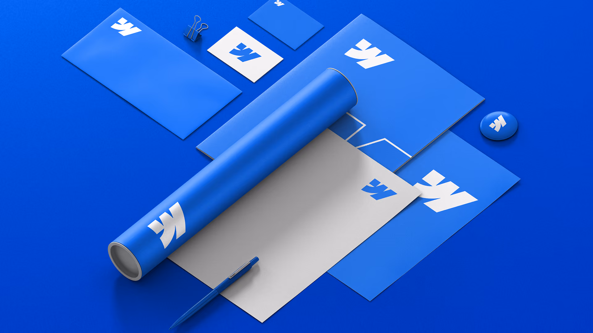 3D-Mockup für blaues Briefpapier und Branding: gerolltes Papier, Karten, Stift, Schere und Umschläge mit weißen Logos auf leuchtend blauem Hintergrund.